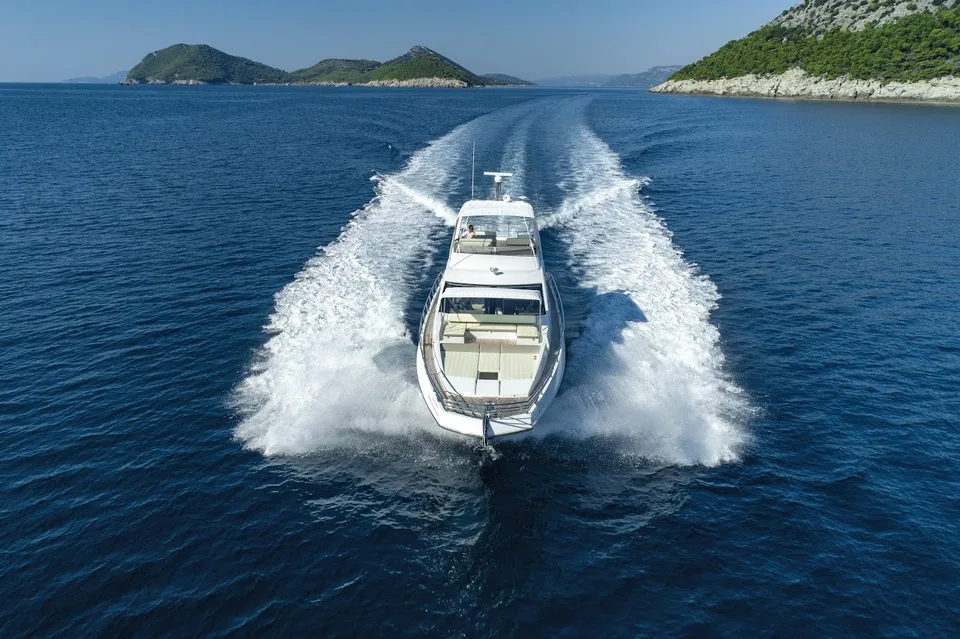 Azimut 66 Fly luxury yacht cruising the Adriatic Sea near Dubrovnik, leaving a powerful wake under a clear sky.
