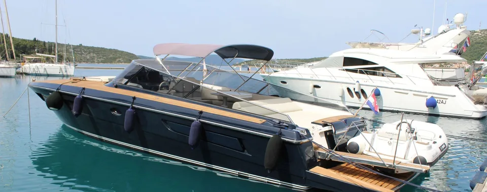 Luxury yacht ITAMA 45 moored in Dubrovnik marina, surrounded by crystal-clear Adriatic waters and lush coastal landscape
