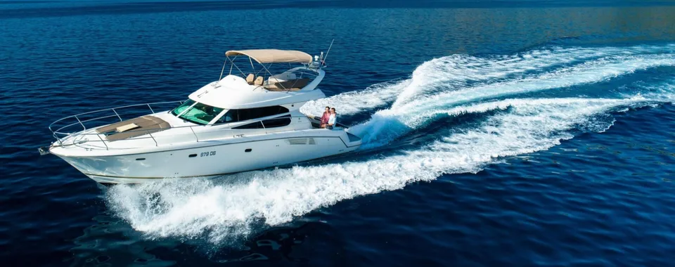 Luxury yacht cruising along Croatian coast near Dubrovnik, with Elaphiti islands and clear blue Adriatic Sea in background