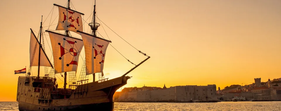 Dubrovnik luxury event ship sailing at sunset beside the Old Town city walls