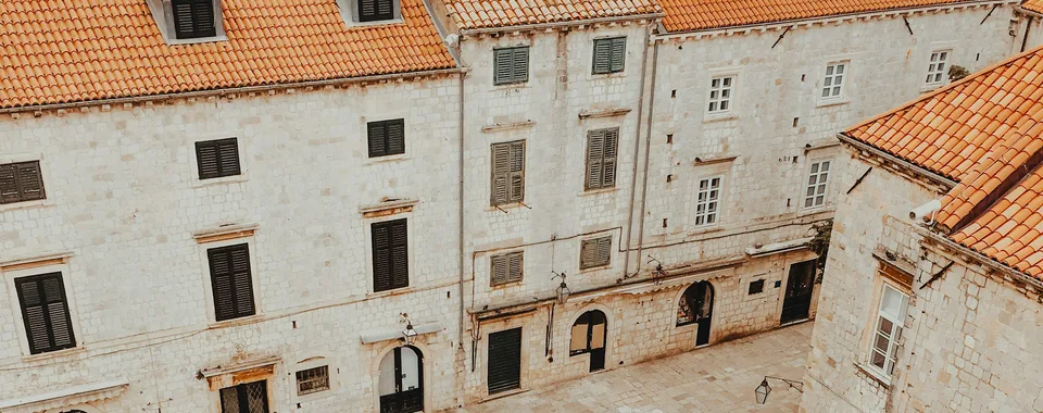 View from Dubrovnik city walls looking down the Stradun main street lined with pedestrians and baroque facades, Croatia