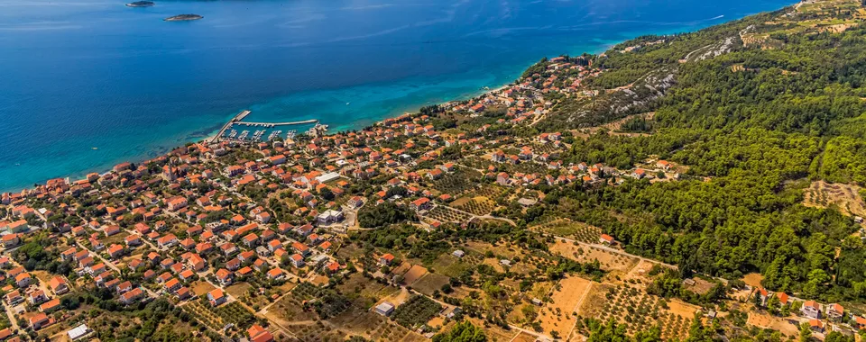 Aerial panorama of Korčula island and Pelješac channel with coastal village, olive groves and turquoise Adriatic Sea, Croatia