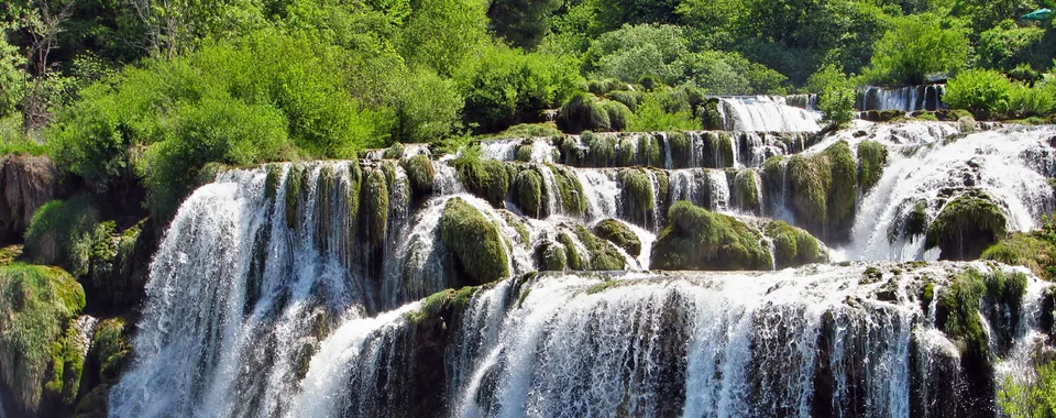 Multi-tiered Skradinski Buk waterfall with white rushing water over moss-covered travertine rocks in Krka National Park, Croatia