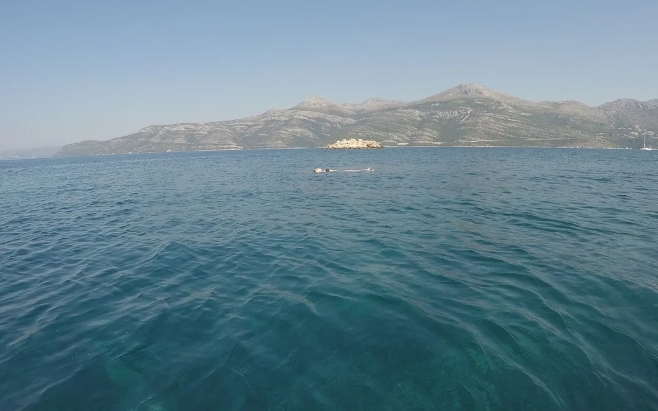  Sparkling turquoise Adriatic Sea with Dubrovnik county in the background, viewed from a private boat near Dubrovnik.