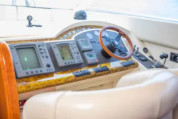 Luxury yacht control panel with modern navigation equipment and wooden steering wheel, ready for Dubrovnik Private Boat Tours