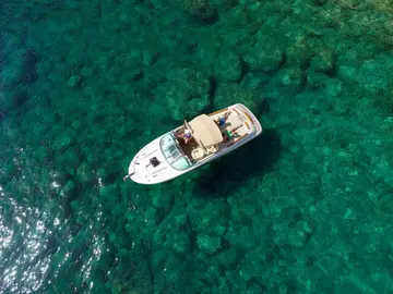 Luxury speedboat anchored in crystal-clear Adriatic Sea near Dubrovnik.