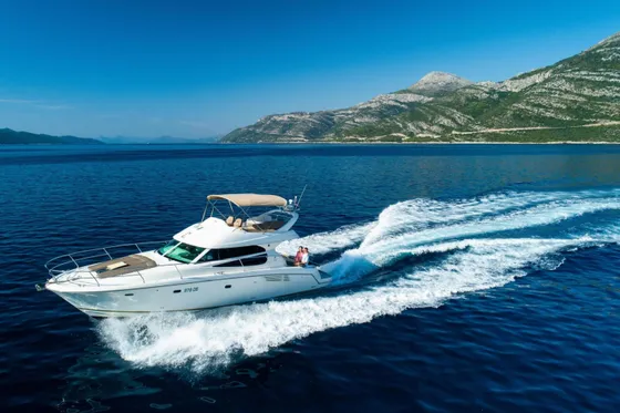 Luxury yacht cruising along Croatian coast near Dubrovnik, with Elaphiti islands and clear blue Adriatic Sea in background