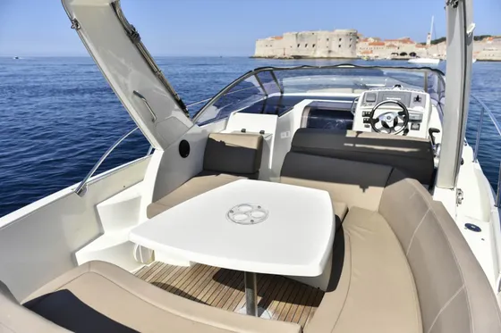Luxury speedboat interior with spacious seating, dining table, and open cockpit, perfect for Dubrovnik day trips.