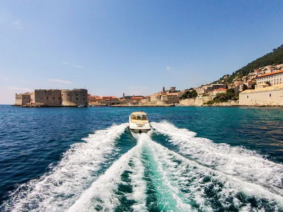 Speedboat leaving Dubrovnik Old Town harbor. Explore the Adriatic with Tendo.