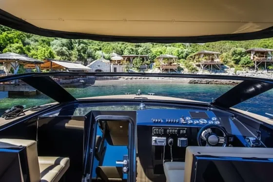 Luxury yacht cockpit view of serene coastal resort with bungalows & clear water, perfect for luxury Dubrovnik escape to islands.