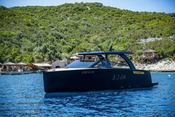 Luxury motor yacht on clear blue water near Dubrovnik island Sipan, waiting for clients in front of popular Bowa restaurant.