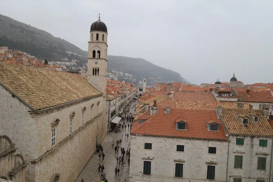 Ancient stone tower and rampart of Dubrovnik city walls rising above limestone buildings in the Old Town, Croatia