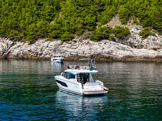 Luxury yacht anchored in a serene Croatian bay with lush green hills and clear blue waters, perfect for Adriatic charters.