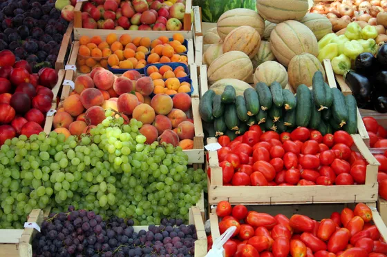 Colourful fresh produce market stall with green grapes, tomatoes, peppers and summer fruit at a Dalmatian outdoor market, Croatia