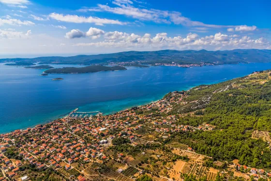 Aerial panorama of Korčula island and Pelješac channel with coastal village, olive groves and turquoise Adriatic Sea, Croatia