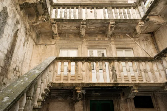 Renaissance stone facade of Marco Polo House in Korčula old town with ornate balustrades, carved friezes and arched windows