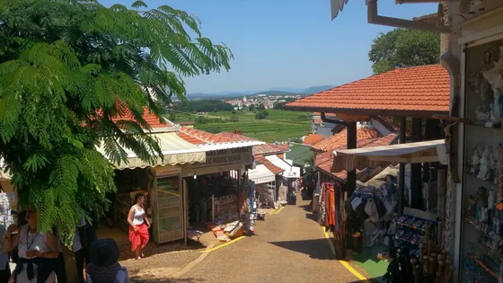 Pilgrim street in Medjugorje lined with souvenir and religious shops, valley view in background