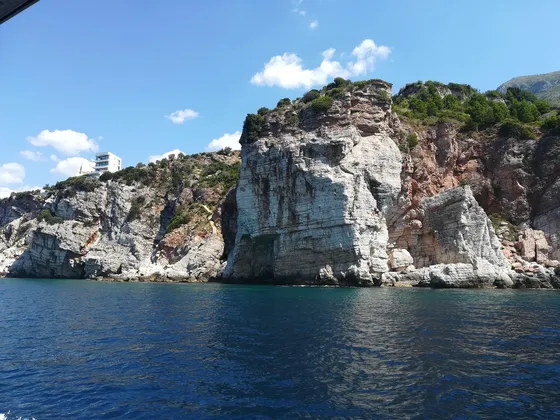 White limestone cliffs and deep blue Adriatic sea along the Montenegrin coast, viewed from a passing boat