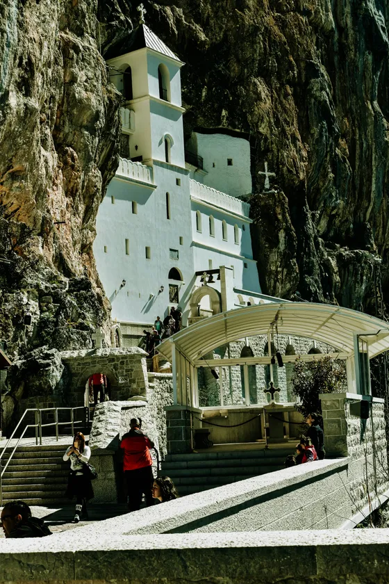 Ostrog Monastery — the white Serbian Orthodox pilgrimage church built into a vertical cliff face in the Montenegrin mountains