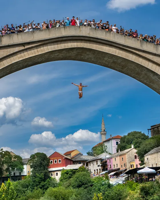 Divers jumping off Stari Most bridge into the Neretva River in Mostar, Bosnia and Herzegovina