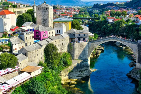 Stari Most Ottoman bridge over Neretva River with Mostar old town stone towers in background