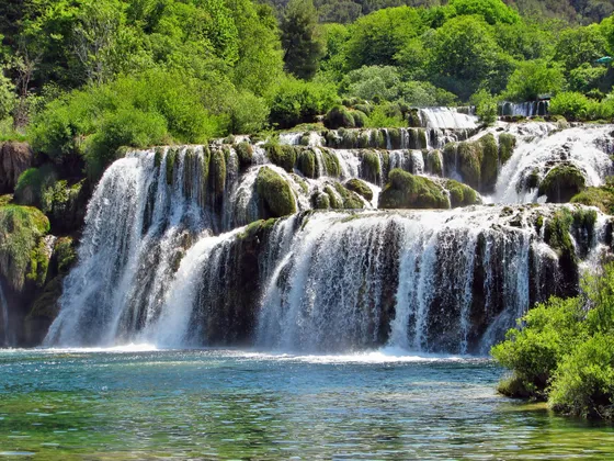 Multi-tiered Skradinski Buk waterfall with white rushing water over moss-covered travertine rocks in Krka National Park, Croatia