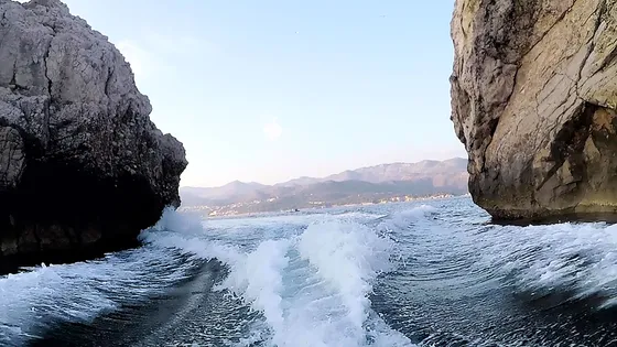Scenic boat journey through rocky coastal formations near Dubrovnik, showcasing crystal-clear Adriatic waters