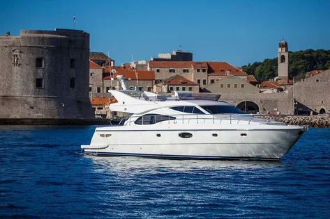 Luxury yacht sailing past Dubrovnik old town walls, Croatia. 