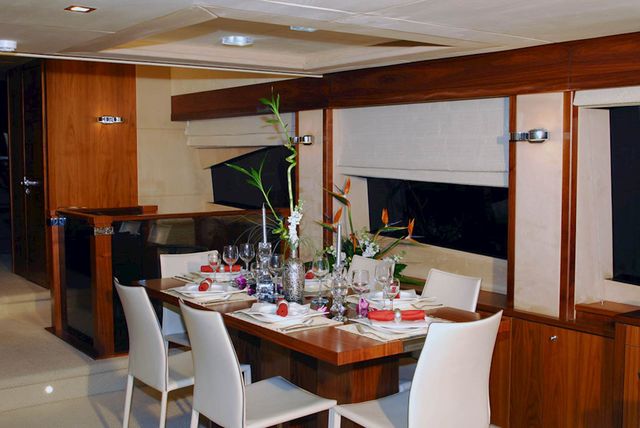 Experience fine dining at sea in our yacht's exquisite interior, featuring a beautifully appointed table and comfortable seating for memorable meals with stunning views.