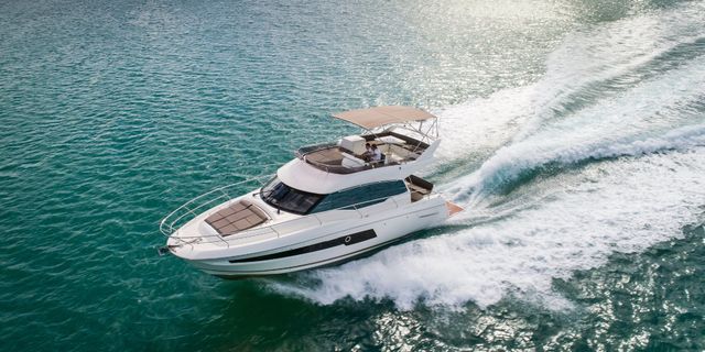 Prestige 420 Fly luxury yacht cruising on sparkling turquoise Adriatic waters near Dubrovnik, Croatia, creating a white wake.