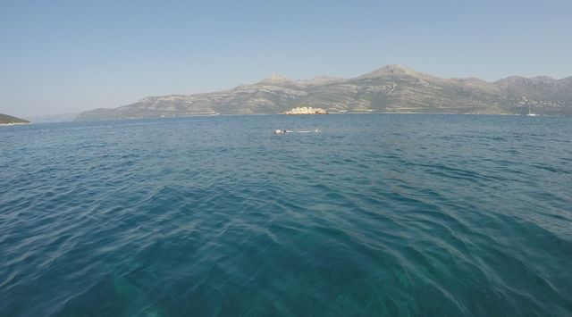  Sparkling turquoise Adriatic Sea with Dubrovnik county in the background, viewed from a private boat near Dubrovnik.