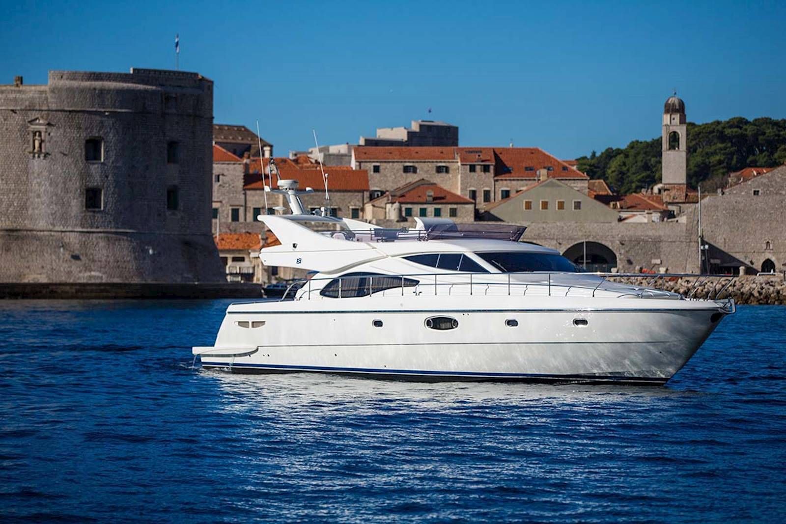 Luxury yacht sailing past Dubrovnik old town walls, Croatia. 